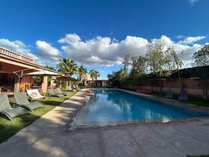 a swimming pool with lounge chairs in a yard at Villa Essalah & Spa Marrakech in Marrakesh