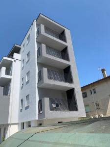 a white apartment building with a dog in the window at Matilde Apartments Caorle in Caorle