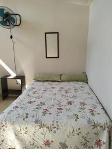 ein Schlafzimmer mit einem Bett mit einer geblümten Tagesdecke in der Unterkunft Hotel Morelia Nova in Morelia