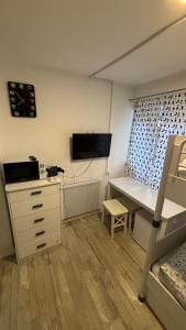 a dorm room with a desk and a bed and a bunk bed at Špeluňka in Luhačovice
