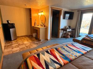 a living room with a bed and a bathroom with a sink at Ninepipes Lodge in Polson