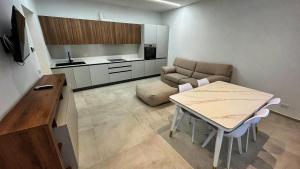 a small living room with a table and a kitchen at Boutique Apartments Magenta in Magenta
