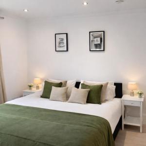 a bedroom with a large bed with green and white pillows at Spacious 2 Bed Apartment with Free Parking, Sleeps Up To 6 in Purley