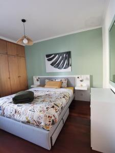 a bedroom with a large bed and a ceiling at Surf Nest in Machico