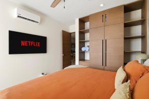 a bedroom with a bed with a netflix sign on the wall at Ocean View Haven Walk to Beach Private Rooftop Terrace in Akumal