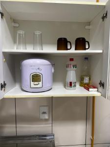 a kitchen shelf with a slow cooker on it at Apt Aconchegante no Centro de Rolim in Rolim de Moura