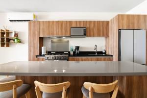 a kitchen with a white counter top and wooden cabinets at Ocean View Haven Walk to Beach Private Rooftop Terrace in Akumal