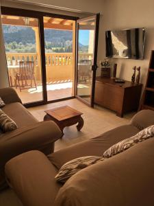 a living room with a couch and a table and a balcony at Pollensa apartament in Pollença