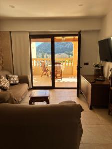 a living room with a couch and a sliding glass door at Pollensa apartament in Pollença