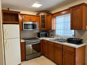 a kitchen with wooden cabinets and a white refrigerator at Casa Quinta Real in Cedro
