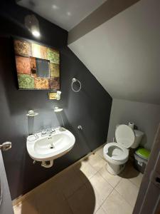 a bathroom with a white toilet and a sink at Casa Quinta Real in Cedro +1 photo