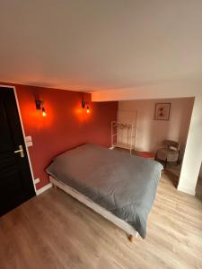 a bedroom with a bed with an orange wall at Appartement neuf & élégant Centre Dunkerque rue de la porte d'eau in Dunkerque
