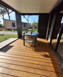 a wooden deck with a table and chairs on it at Chalet in Gouesnach