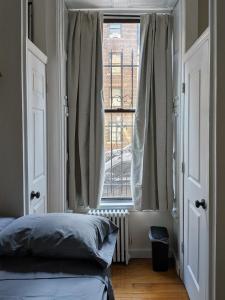 a bedroom with a bed and a large window at Times Square Retreat with Private Bathroom and Kitchenette in New York