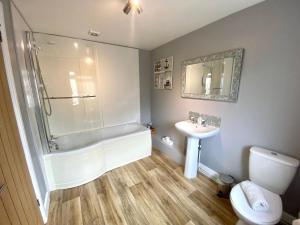 a bathroom with a tub and a sink and a toilet at Mill Lane Holiday Cottage -Bath in Bath