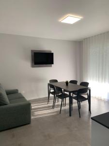 a dining room with a table and chairs and a couch at Matilde Apartments Caorle in Caorle