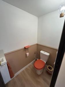 a small bathroom with a toilet with a red seat at Appartement neuf & élégant Centre Dunkerque rue de la porte d'eau in Dunkerque +4 photos
