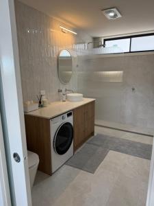 a bathroom with a sink and a washing machine at Banksia apartment - Escape to Serene Rural Bliss! in Inverell +16 photos
