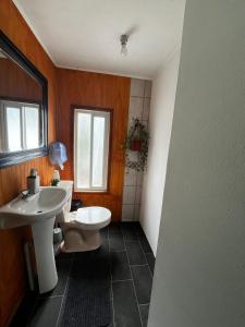 a bathroom with two sinks and a toilet at Fungi Hostal in Coihaique
