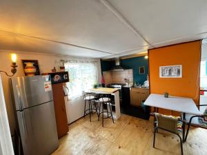a kitchen with a refrigerator and a table with chairs at Fungi Hostal in Coihaique +18 photos