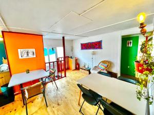 a living room with green and orange walls and tables at Fungi Hostal in Coihaique