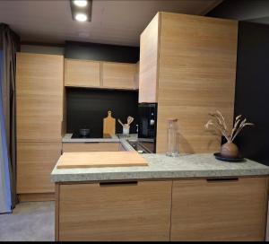 a kitchen with wooden cabinets and a counter top at Chalet in Gouesnach