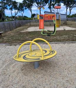 a playground with a yellow board in a park at Chalet in Gouesnach +8 photos