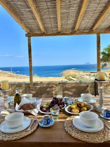 a table with food and a view of the beach at Aegean Paradise, Kythnos, Naousa in Kithnos