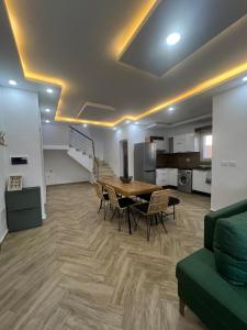 a living room with a table and chairs and a kitchen at Maison des 5 palmiers in Taguermess