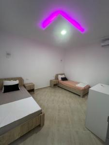 a bedroom with two beds and a pink ceiling at Maison des 5 palmiers in Taguermess +18 photos