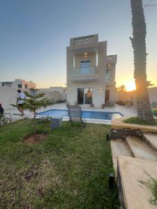 a view of a house with a swimming pool at Maison des 5 palmiers in Taguermess