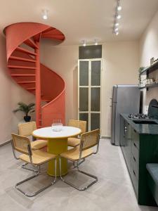 a kitchen with a table and chairs and a spiral staircase at Beit'roun 2BR Apartment in Batroun in Batroûn