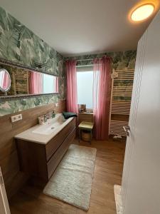 a bathroom with a tub and a sink and a window at Panorama Joy - stilvolle Gemütlichkeit mit Weitblick in Schmallenberg +63 photos