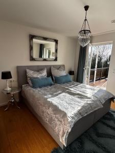 a bedroom with a large bed and a mirror at Panorama Joy - stilvolle Gemütlichkeit mit Weitblick in Schmallenberg