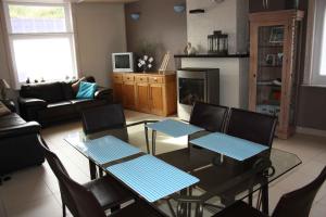 a living room with tables and chairs and a fireplace at Vakantiewoning Cosy Corner in Ypres