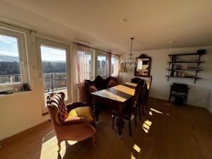 a dining room with a table and chairs and windows at Panorama Joy - stilvolle Gemütlichkeit mit Weitblick in Schmallenberg