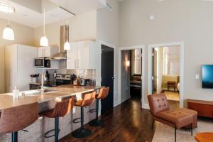 a kitchen with a counter and chairs in a room at Downtown Luxe 2BR Loft Apt | Sleeps 8 | Walkable in Milwaukee