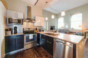a kitchen with a sink and a stove top oven at Downtown Luxe 2BR Loft Apt | Sleeps 8 | Walkable in Milwaukee +18 photos