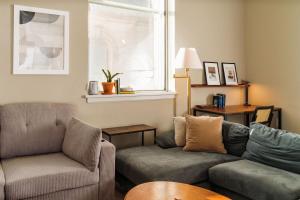 a living room with a couch and a chair at Downtown Luxe 2BR Loft Apt | Sleeps 8 | Walkable in Milwaukee