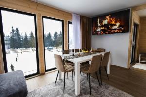a dining room with a table with chairs and a fireplace at Cabana Almora in Dorna Arini