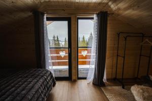 a bedroom with a bed and a large window at Cabana Almora in Dorna Arini