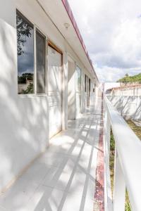 a white building with windows and shadows on the sidewalk at HOTEL LOS CEDROs in Yalsí