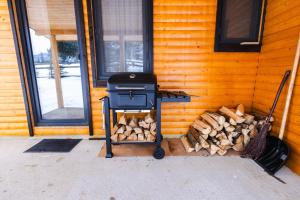 a stove with a pile of wood next to a house at Cabana Almora in Dorna Arini