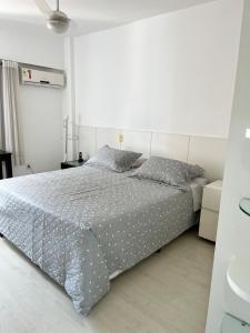 a white bedroom with a bed with gray sheets and pillows at Enseada do Suá Golden Gate - Moderno e Espaçoso in Vitória +37 photos