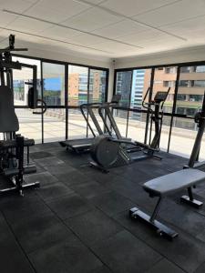 a gym with cardio equipment in a building with windows at Enseada do Suá Golden Gate - Moderno e Espaçoso in Vitória