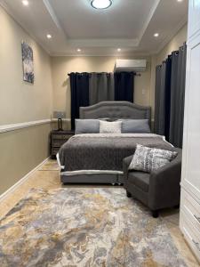 a bedroom with a large bed and a couch at Lumiere Suites in Georgetown
