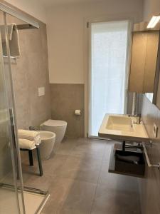 a bathroom with a tub and a toilet and a sink at Matilde Apartments Caorle in Caorle +10 photos