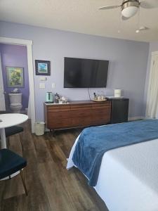 a bedroom with a bed and a flat screen tv at Global Village Permaculture BnB in Oliver