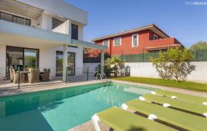 a swimming pool with two lounge chairs and a house at Oasis N'aguait in Cala Ratjada