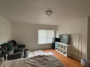 an empty living room with a couch and a window at LA Lux Suite with Private Bathroom in Santa Clarita